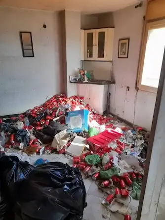 Habitació plena d'objectes i brossa abans del buidat