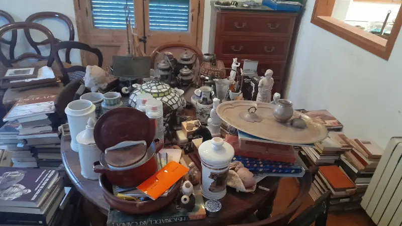 Objetos y enseres de una vivienda heredada sobre una mesa antes del vaciado en Barcelona